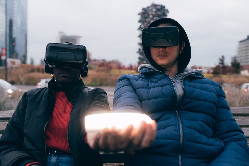COUPLE WITH VR GOGGLES HOLDING GLOWING OBJECT IN CITY