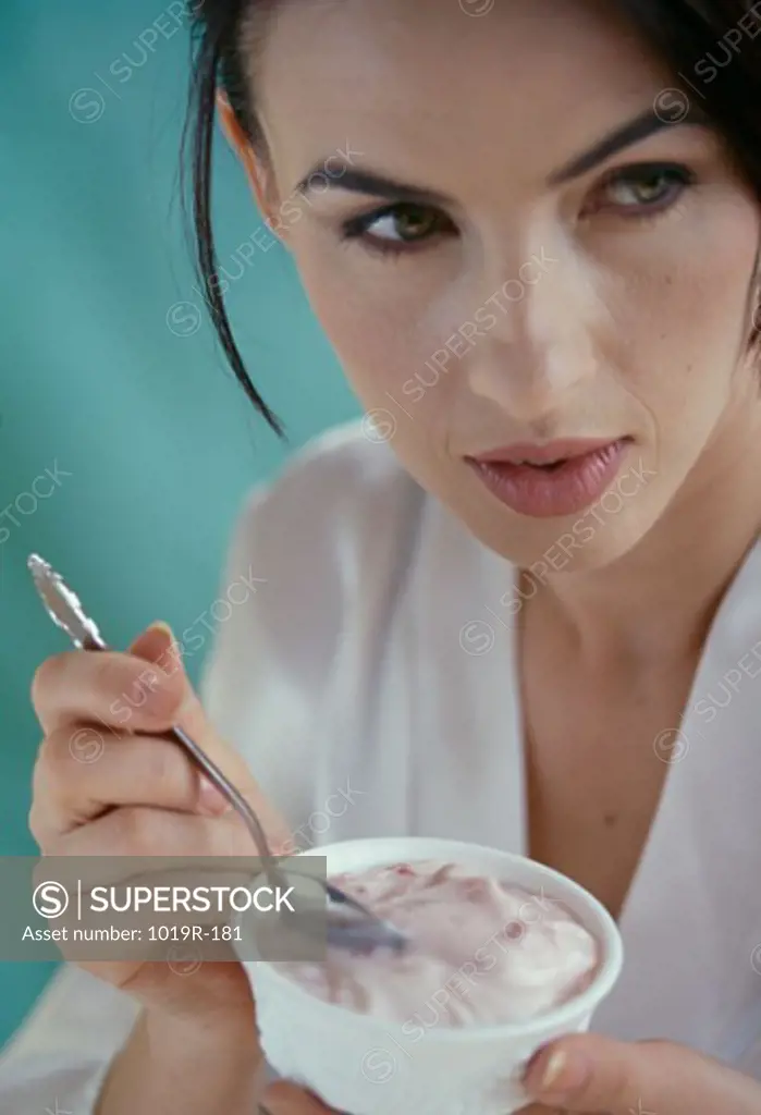 Close-up of a young woman holding a bowl of yogurt