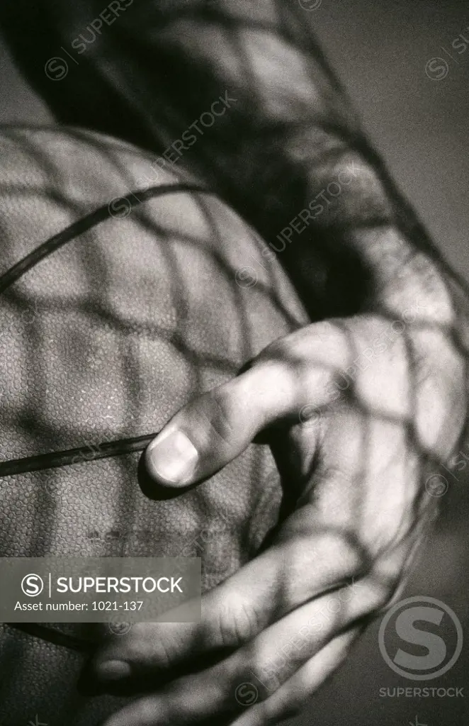 Close-up of a person's hand holding a basketball
