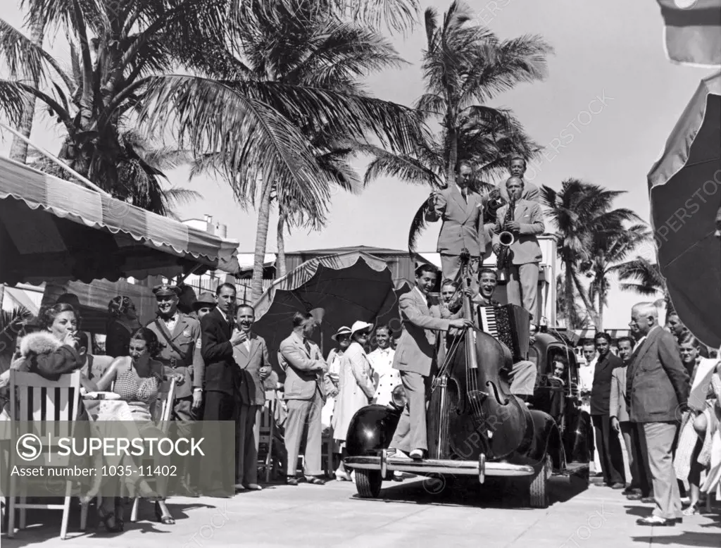 Miami, Florida:  c. 1933. Diners at the Roney Plaza's Cafe de la Paix are entertained by the Meadowbrook Boys as they cruise through the luncheon groups on their traveling bandstand.©Underwood Archives