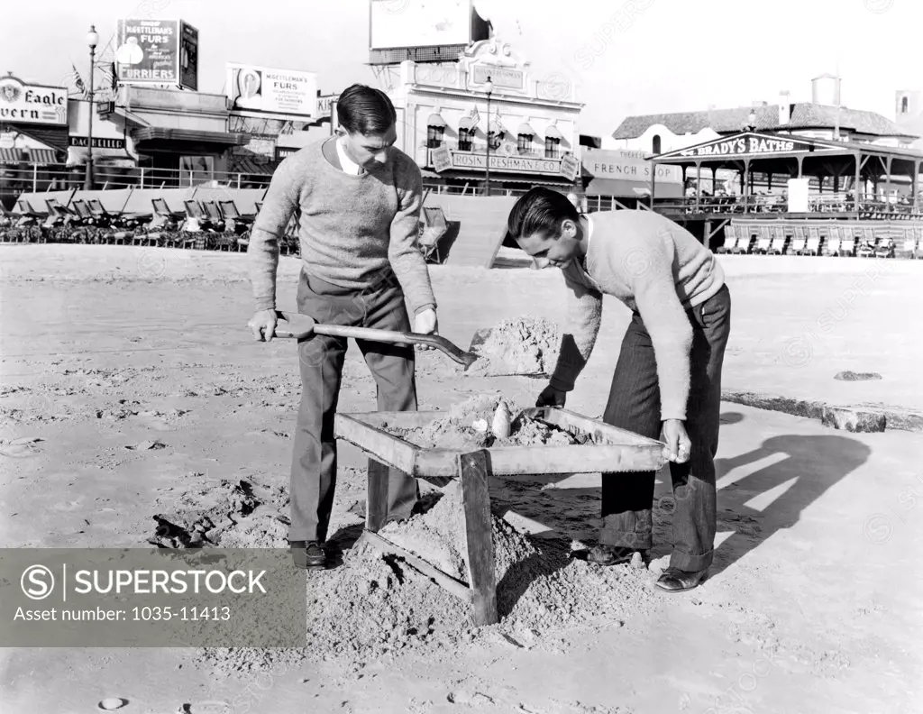 Atlantic City, New Jersey:  c. 1935. Jobless college graduates have joined the ranks of beachcombers who daily sift the Atlantic City sands in search of valuables lost by the millions of summer bathers..©Underwood Archives