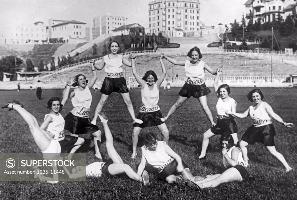 Madrid, Spain:  c. 1926. Girls from the Romea Theater doing a variety of exercises on the soccer field during the halftime of their game with the Metropolitano Theater girls.