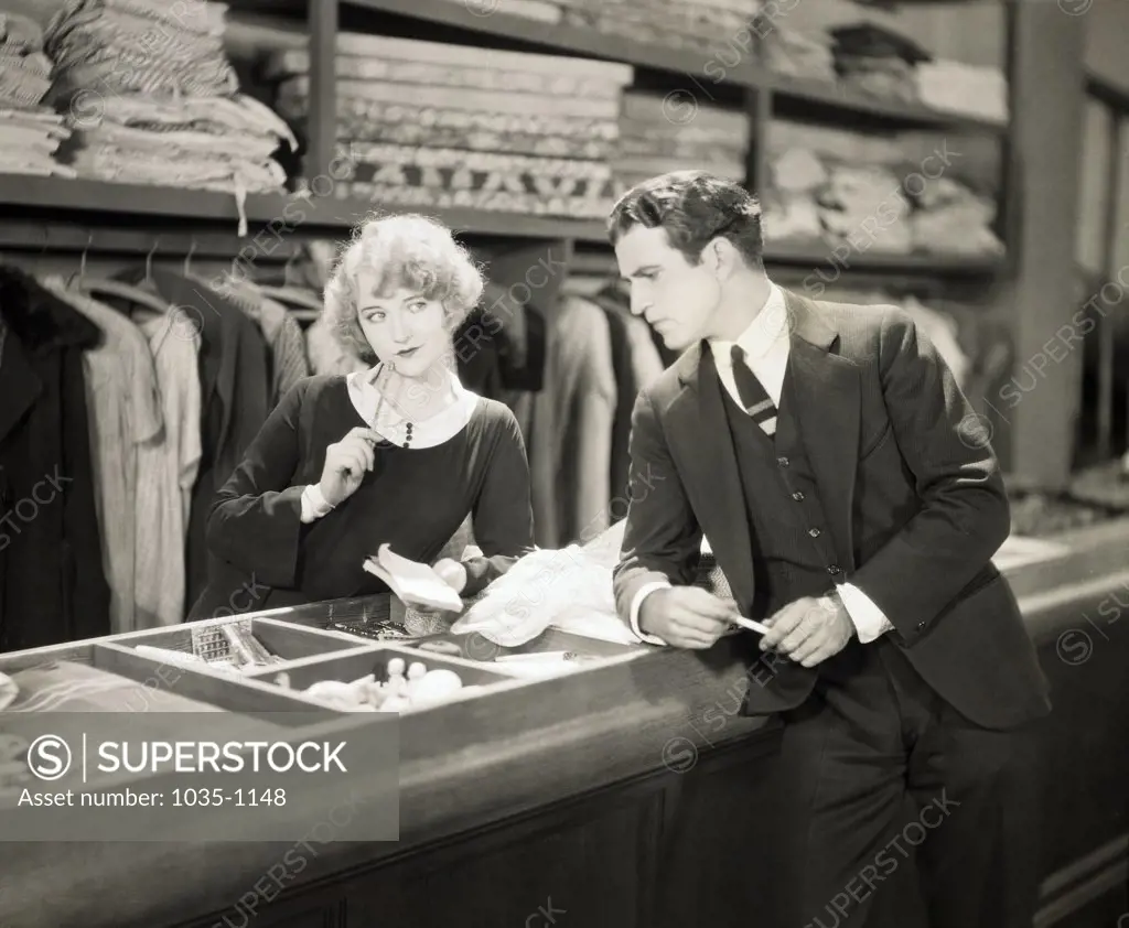Young man standing in front of a counter of a clothing store