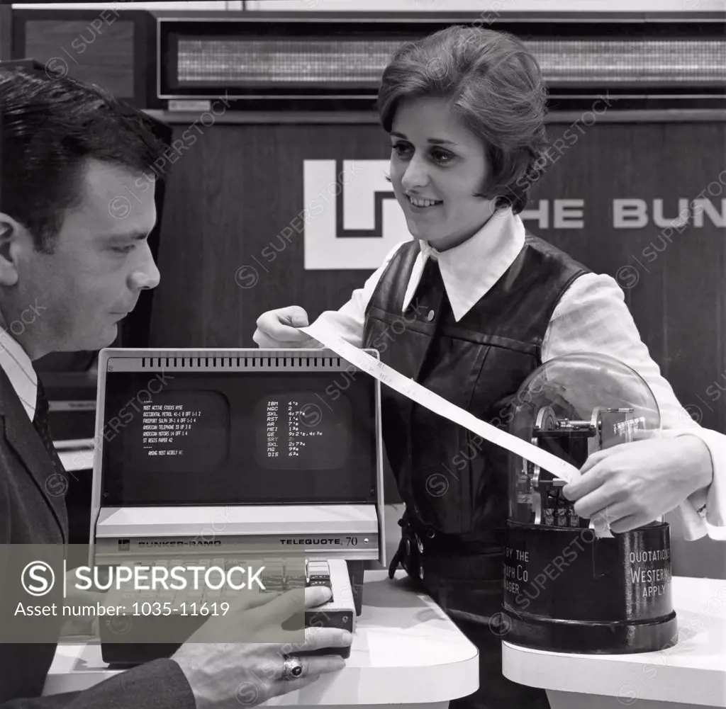 New York, New York:  c. 1966. New computers aided stock quotations in the 1960's. Here, stock exchange employees compare the old ticker tape and new computerized systems.