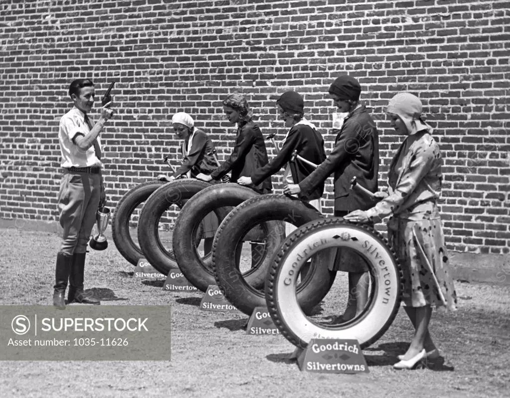 Hollywood, California:  c. 1927. Bobby Trout, famous aviatrix, started the test where five girls of the Albertina Rasch ensemble  drove 180 nails into Goodrich Silvertowns tires without causing a single puncture.