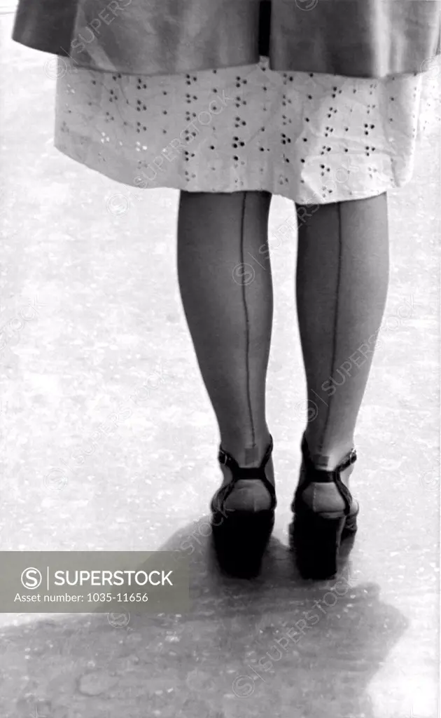 United States:  c. 1950. A woman legs from the back showing the seams in her stockings.