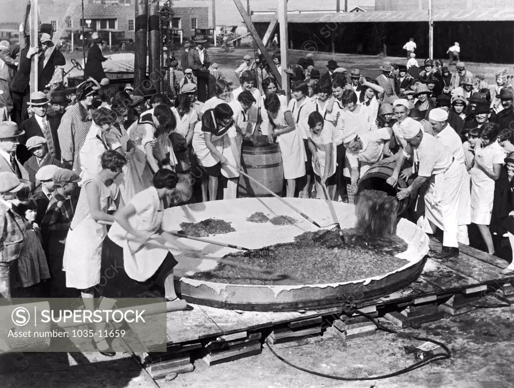 Yakima, Washington:   October, 1927. Bakers loading the 400 gallons of apples used to make the world's largest apple pie to celebrate National Apple Week in Yakima. The pie is 10 feet across, and it took five cords of wood to heat the oven to bake it. It weighs 1 ton, and was consumed by 2000 school children.