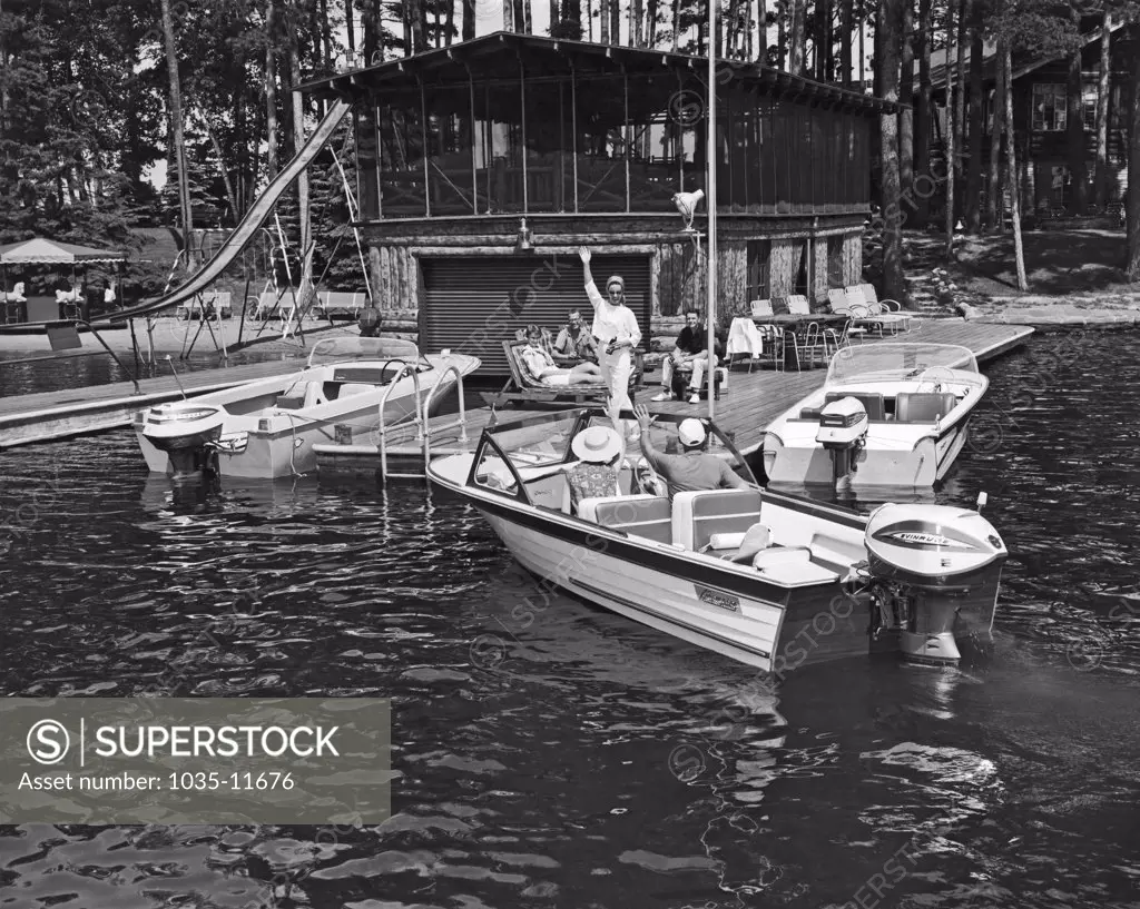 United States:  c. 1960. A couple arrives by motor boat to join others on the deck.