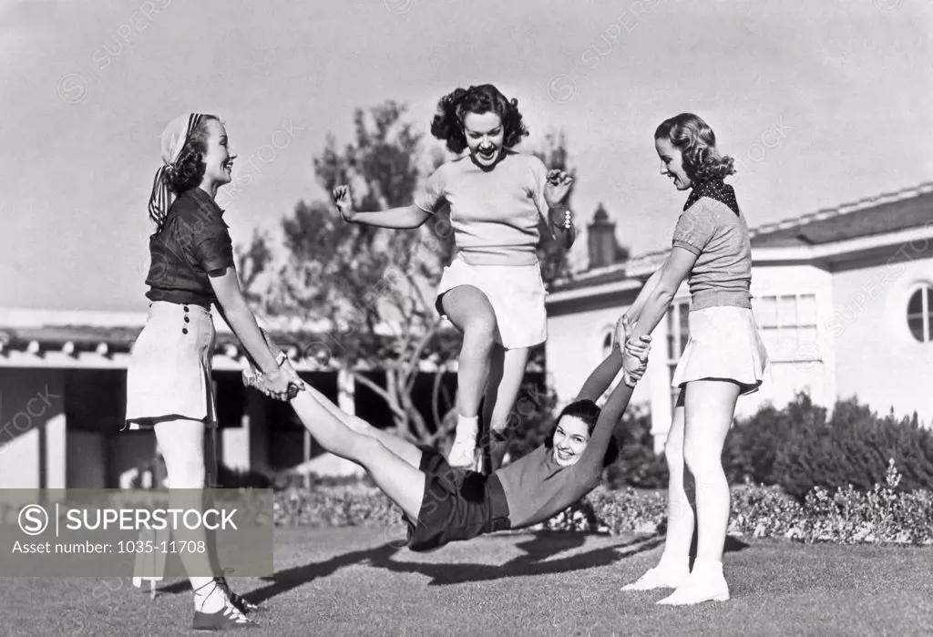 Hollywood, California:  1938. Margaret Randall and Marion Weldon swing Paula De Cardo as a human jump rope for Gwen Kenyon to celebrate the completion of the Paramount picture, 'College Swing'.