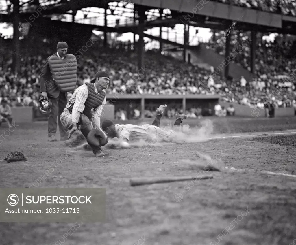 Washington, D.C.:  c. 1926. The Yankees Lou Gehrig scores head first in the fourth inning as Joe Harris's throw gets away from catcher Hank Severeid of the Washington Senators. The Yanks beat the Senators 3-2.