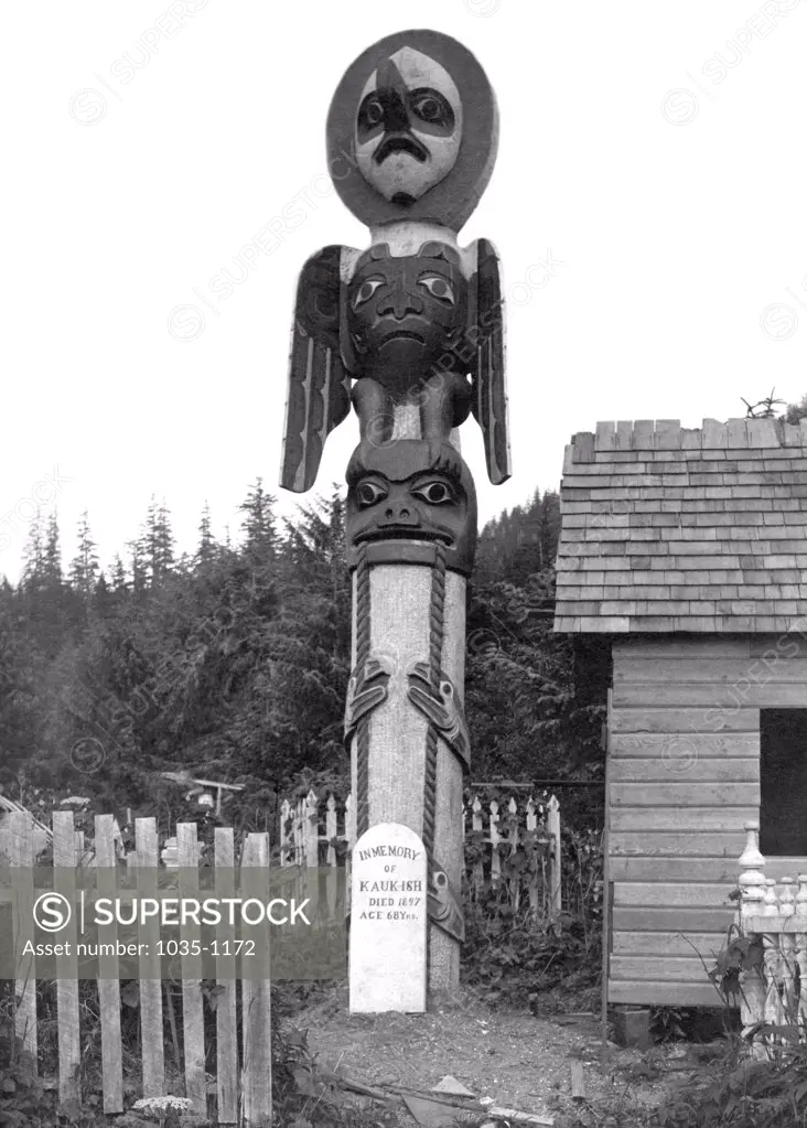 Alaskan Totem Pole with a tombstone, Alaska, USA