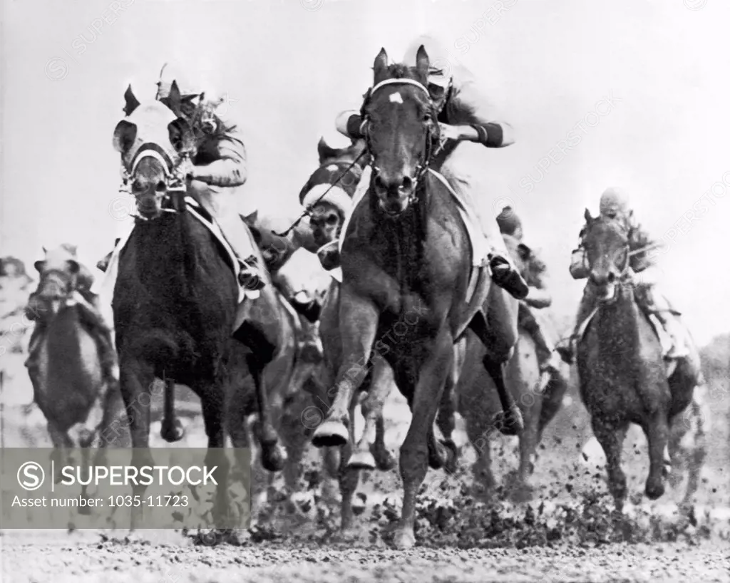 Oceanfront, New Jersey:  June 10, 1961. White River with jockey Tommy Barrow in the saddle splashes through the mud down the backstretch to a victory.