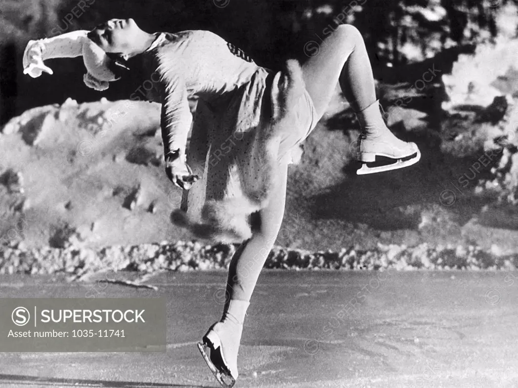Switzerland:  c. 1935. Miss Nadine Szilassy shows her beauty, grace, and poise as she strikes a pose on the ice in Switzerland.