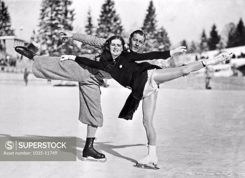 Berlin, Germany:  c.1937. With a matching arabescque, this ice skating pair poses for the camera.