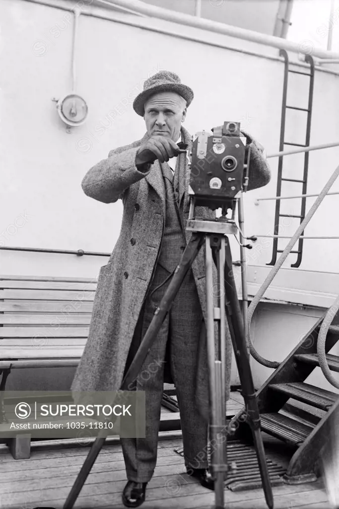 c. 1929. Russian opera singer Feodor Chaliapin aboard a ship with a movie camera.