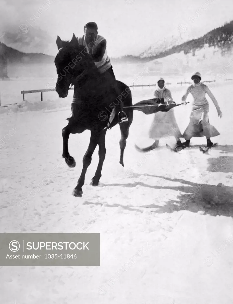 Jena, Germany: c. 1895. Two skiers enjoying the sport of skijoring behind a horse on a snow covered road in Germany.