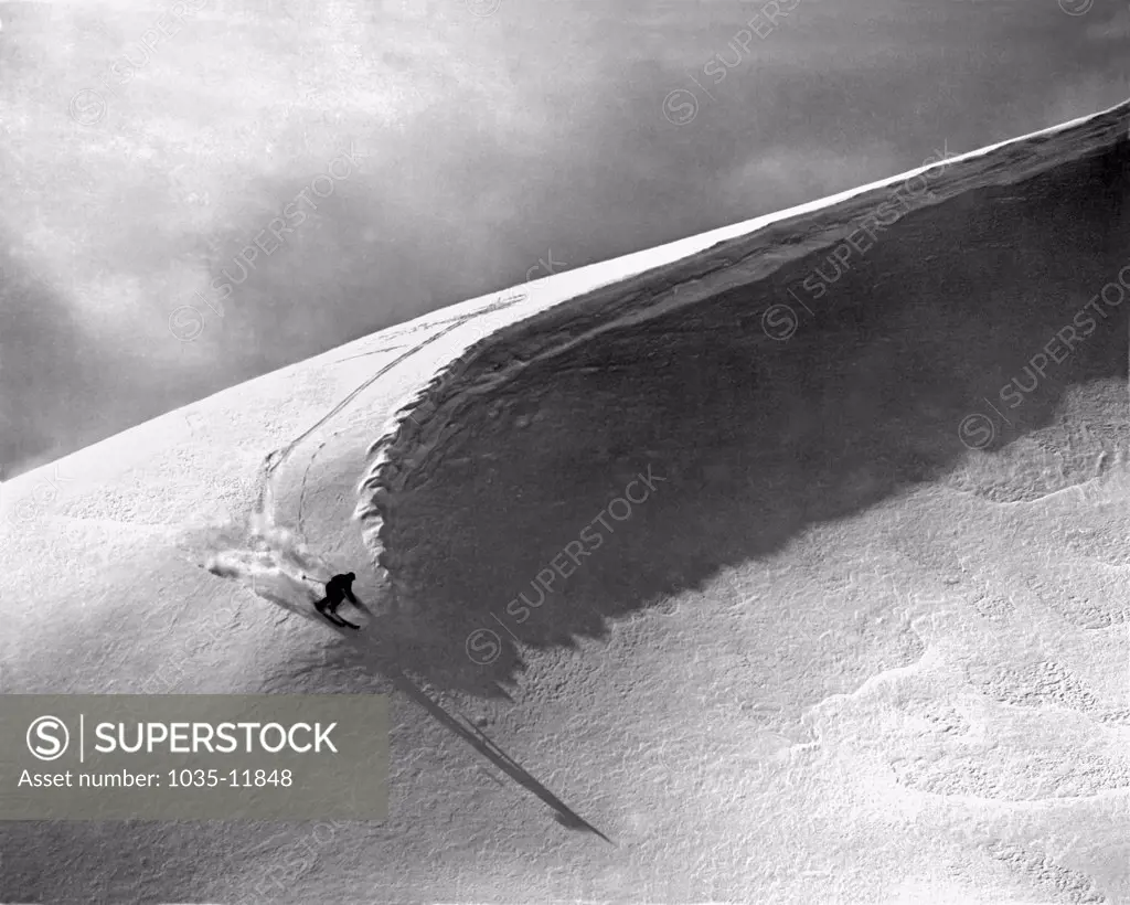 Lake Louise, Alberta,  Canada:  c. 1951. A skier cuts under a snow curl in the Rocky Mountains.