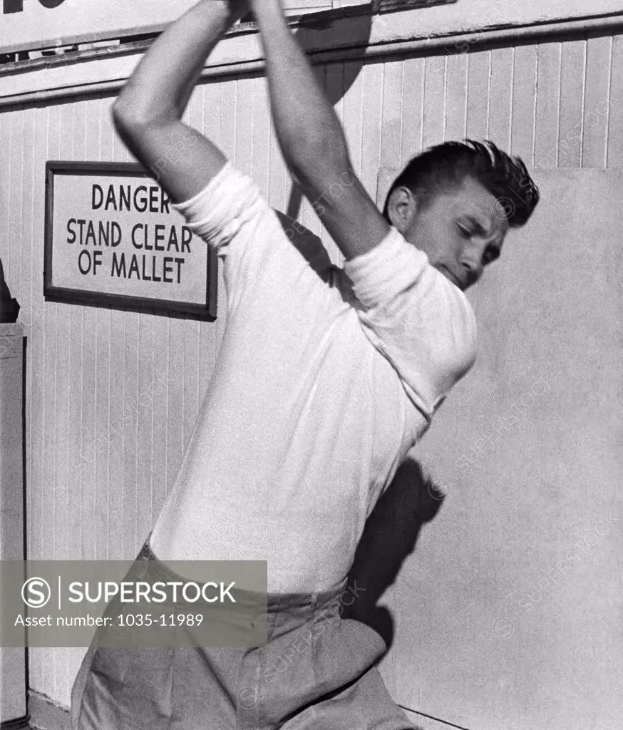 San Francisco, California:  c. 1951. A man tests his strength by trying the 'Ring The Bell' with a mallet at Playland.