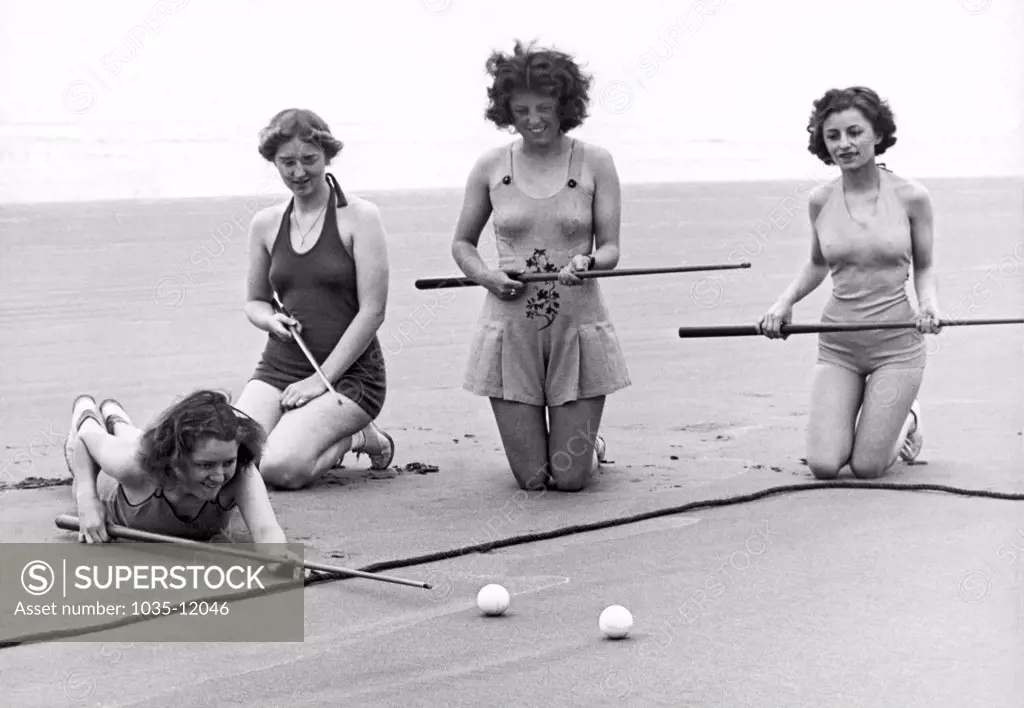 Seaside, Oregon:  c. 1937. The latest in beach sports in Oregon is sand pool, here being played by four of the lovely locals.