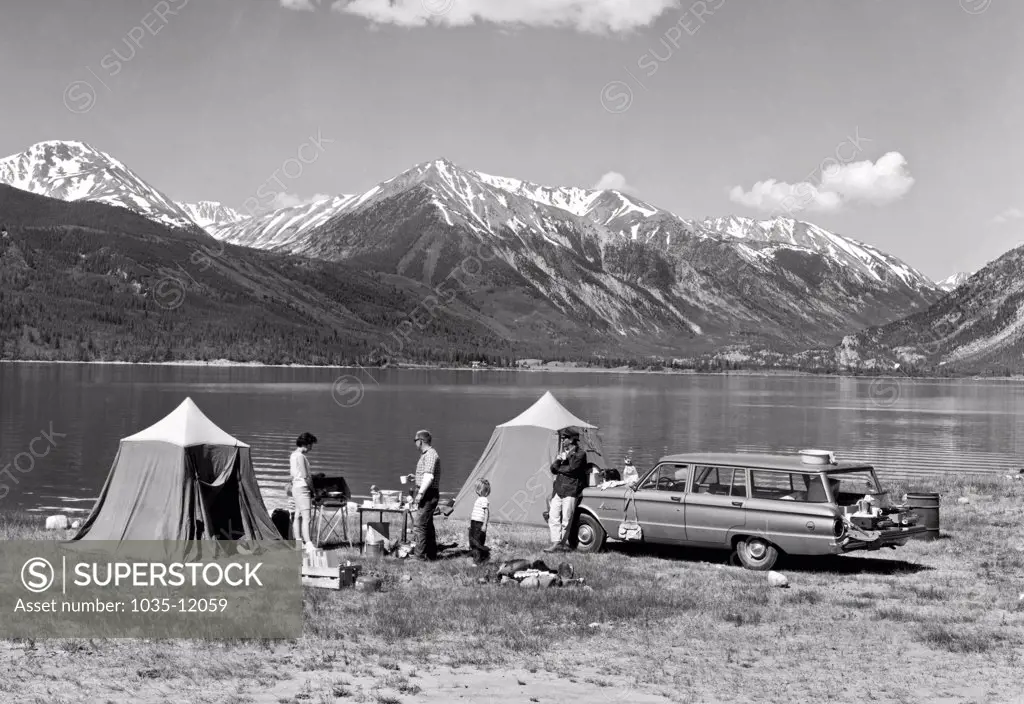 Colorado:  c. 1959. A family car camps by a lake set high in the Rocky Mountains.