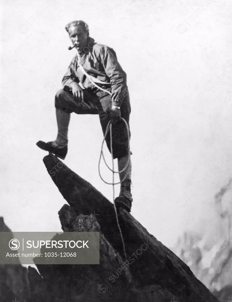 Switzerland:  c. 1925. A mountaineer takes a break on a pinnacle of Mount Matterhorn.