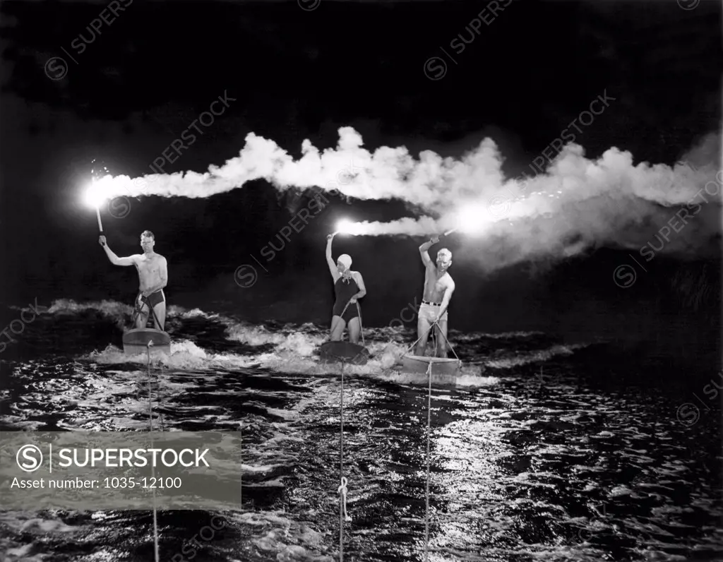 Spring Lake Beach, New Jersey:  June 7, 1938. 'Riders of the skidding planes' light up the sky as they ride their aquaplanes under the illumination of fiery torches.