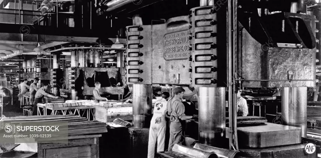 Santa Monica, California:  c. 1942. A Douglas Aircraft plant using extremely hard rubber as part of the dies to cut and form aluminum parts for airplanes for the World War II production effort. The rubber is compressed to the hardness of steel, and using the Guerin process, is forced into the dies to create the sheetmetal parts.