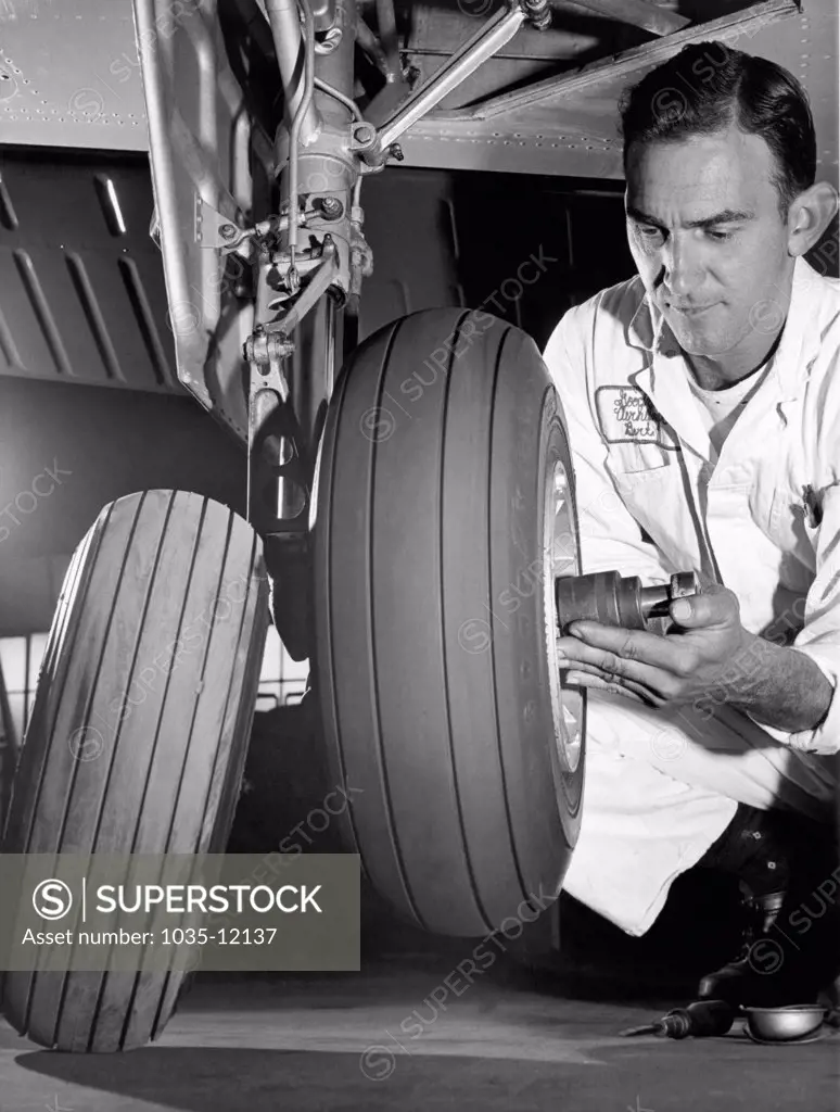 Akron,  Ohio:  c. 1967. An aircraft mechanic changes the old tire for one of Goodyear's new wide rib tires that puts more rubber on the ground and improves tread wear.
