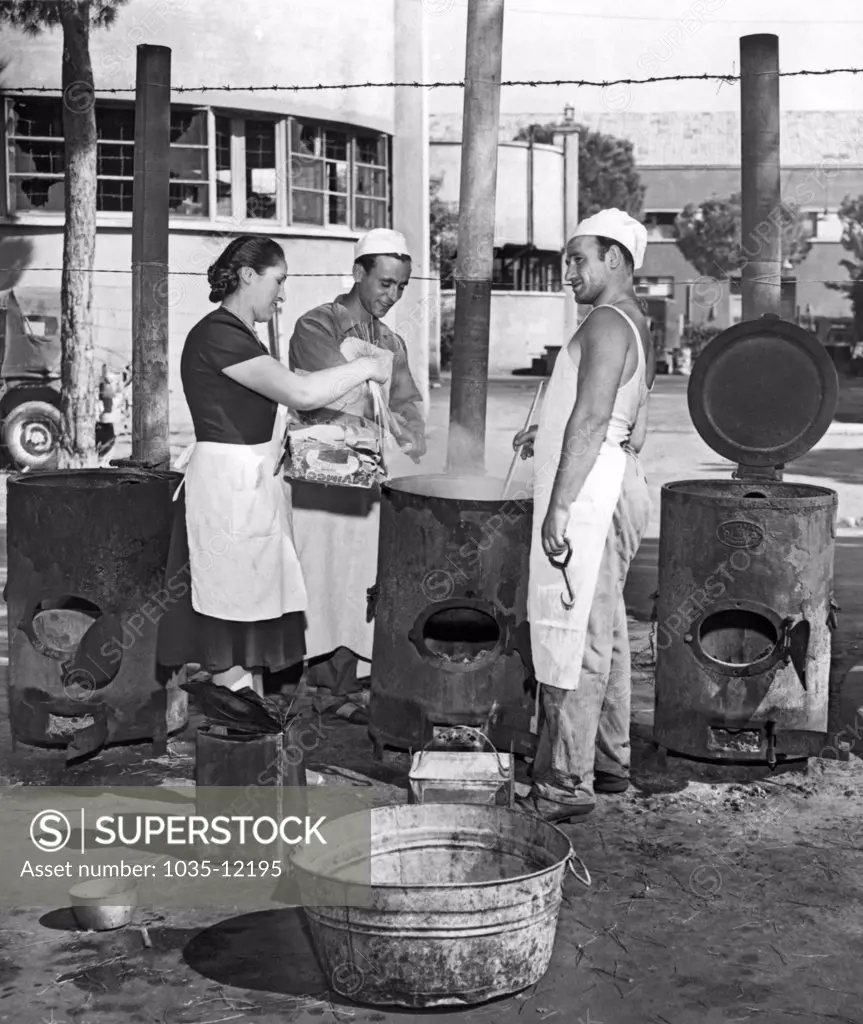 Rome, Italy:  August 23, 1947. Cinecitta, the fabulous movie making center built by Mussolini, now serves as a refugee camp in post war Italy. Here the cooks in one of the outdoor kitchens prepare macaroni for the refugees.