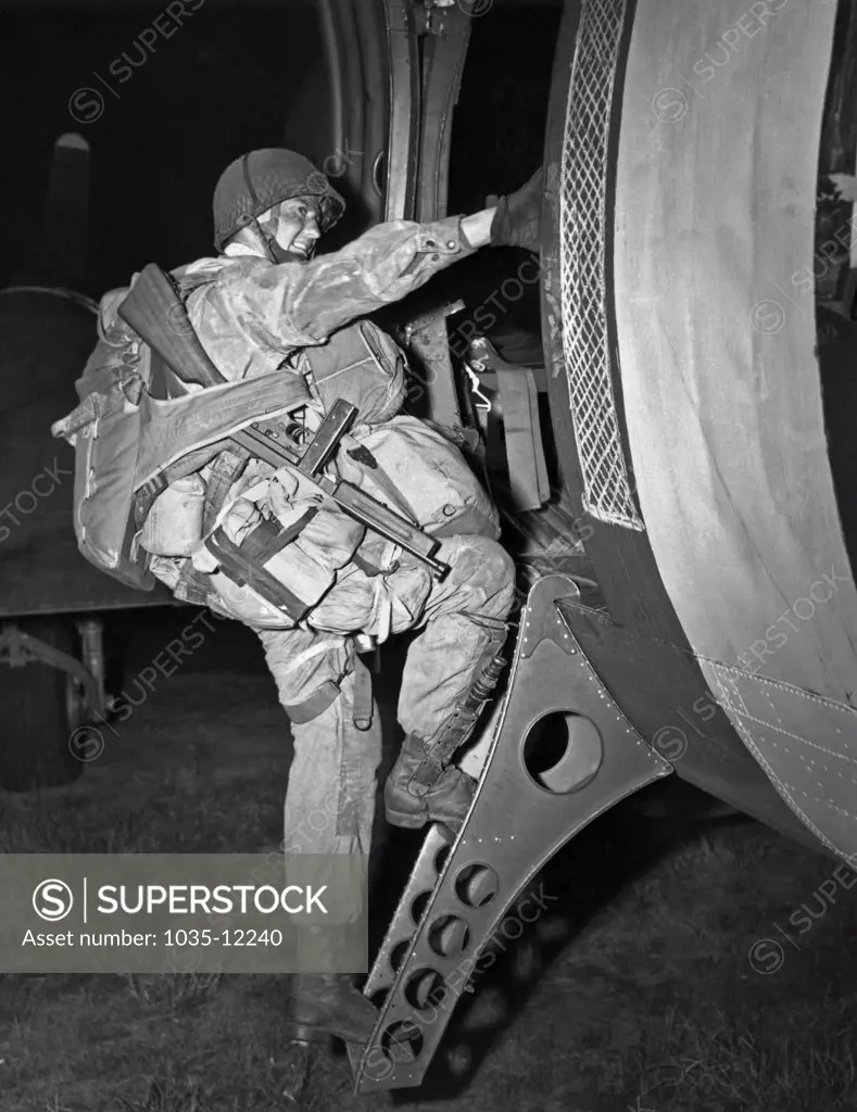 Europe:   June 6, 1944. A paratrooper with all his tools of the trade gets ready for the D-Day drop.