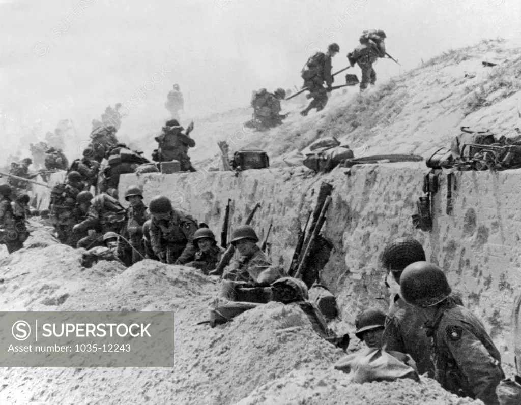 Normandy, France:  June 9, 1944. American troops of the 4th Infantry Division at Utah Beach taking a breather before continuing the assault over the hill to the interior of France.