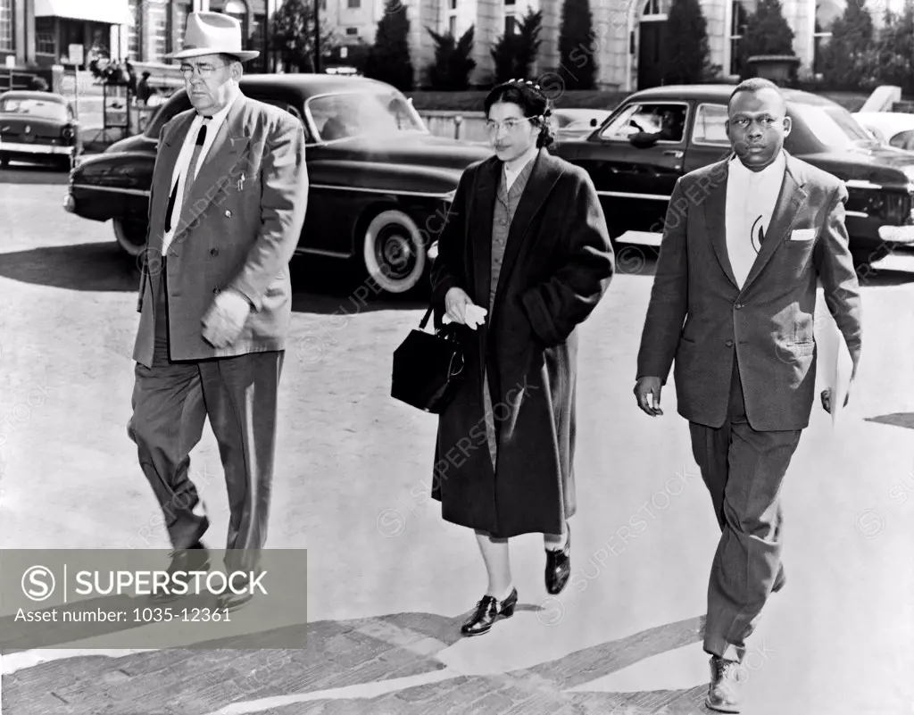 Montgomery, Alabama:  February 2, 1956. Rosa Parks walking between her attorney, Charles D. Langford, and an unidentified deputy, on her way to jail in Montgomery, Alabama.