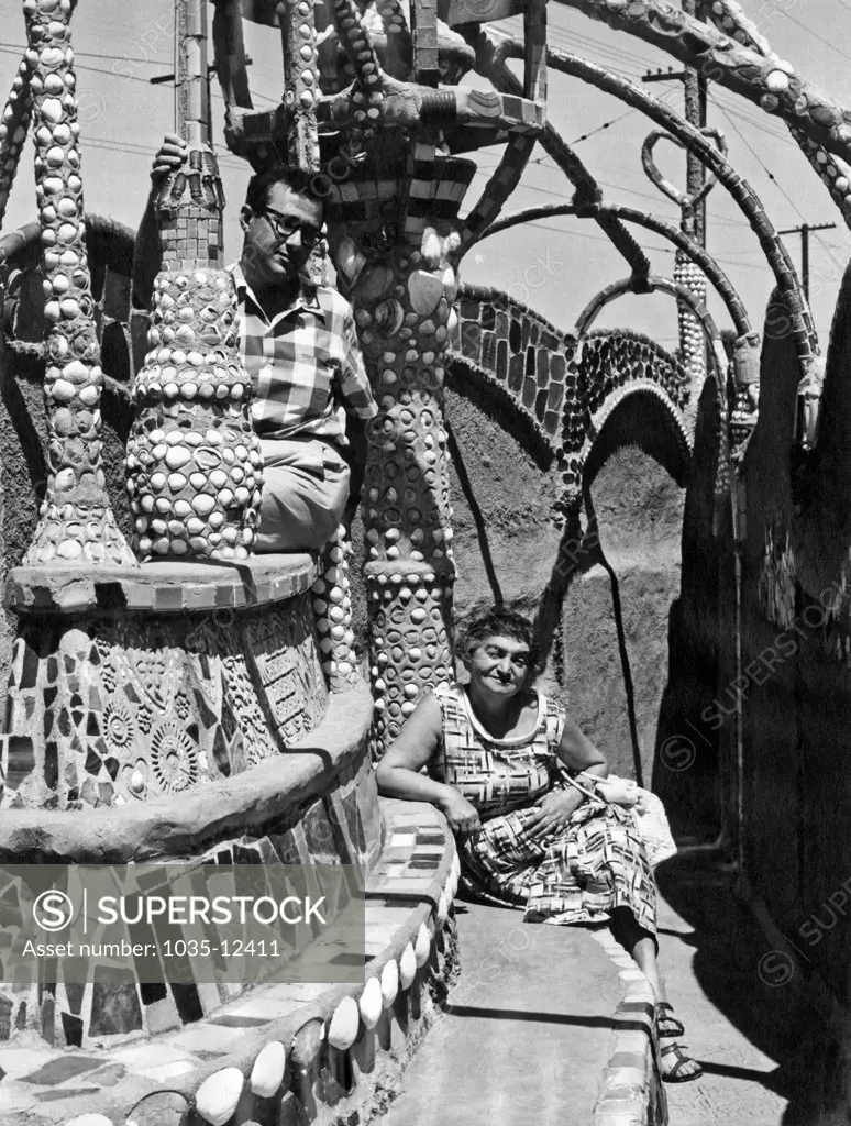 Los Angeles, California: c. 1960. Two visitors at the Watts Towers in the Watts distirct of Los Angeles.