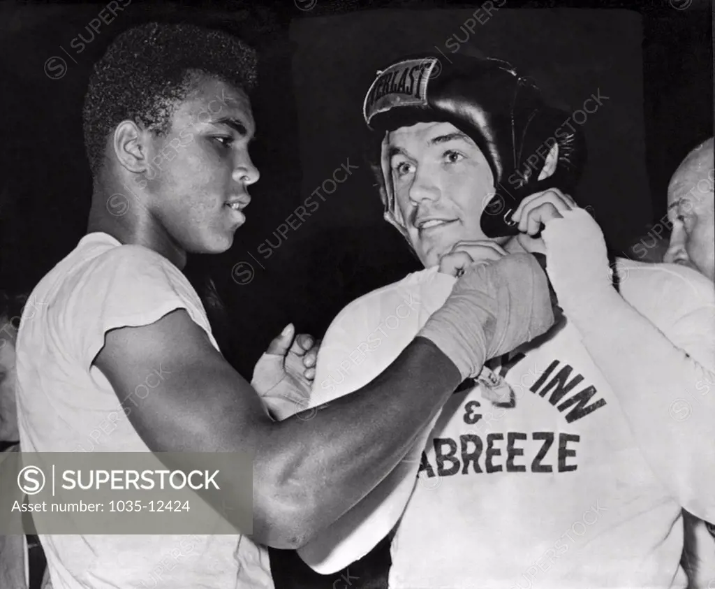 Catskills, New York: 1961 Light heavtweight Cassius Clay gives an assist to heavyweight challenger Ingemar Johansson before going a couple of rounds as his sparring partner for Johansson's upcoming title fight with Floyd Patterson.