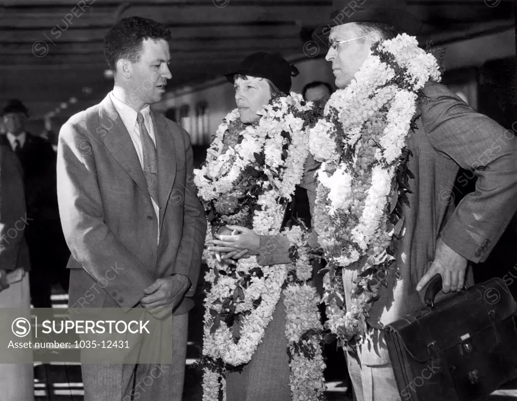Honolulu, Hawaii:  December 27, 1934. Amelia Earhart and her husband, George Putnam, are greeted by Lt. Johnson of the Naval Fleet Air Base.