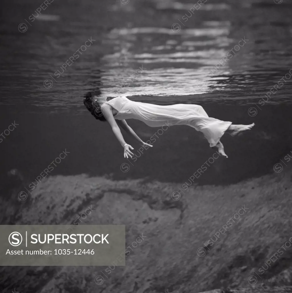 Weeki Wachee, Florida:  1947. An underwater fashion photograph of a woman, wearing a long gown, floating on her back at the Weeki Wachee Spring in Florida.