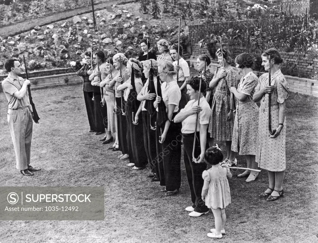 London, England:  August 10, 1940. Twenty units of the Amazon Defense Corps have been trained by England's Home Guard in preparation for a Nazi invasion. Here the women are being trained in the use of firearms.