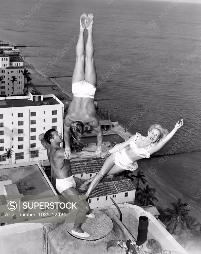 Miami Beach, Florida:  November 15, 1951 The Wayne-Marlin trio rehearses atop the chimney of the Lord Tarleton Hotel. George Wayne Long holds Glen Marlin Sundby and his sister Dolores with no apparent effort twenty stories above the ground.