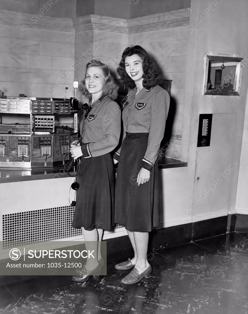 New York, New York:  c. 1943 Women were employed at the NY Stock Exchange during the war, filling in for the men overseas. These two are carriers receiving instructions.