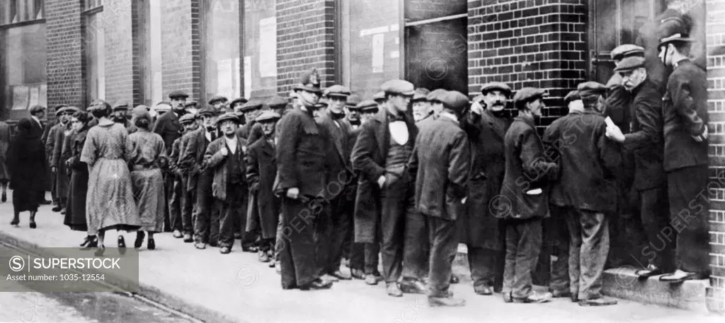 London, England:  c. 1923 Unemployed men in London standing in line at the Employment (Dole Line) Exchange.