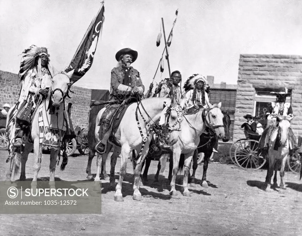 Cody, Wyoming:  October, 1907 On horseback by the First National Bank in Cody, (L-R) Iron Tail (Ogala Sioux), Col. William Cody (Buffalo Bill), Unknown, Chief Plenty Coups (Crow Nation).
