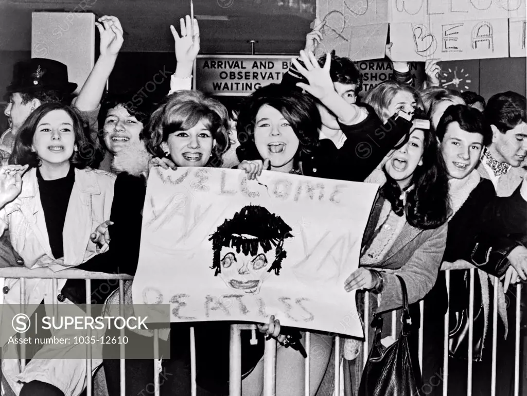 New York, New York:  February 7, 1964. Screaming teenagers wave a crude sign as they welcome 'The Beatles' - Britain's shaggy-haired rock n' roll singers - upon their arrival at New York's John F. Kennedy Airport.