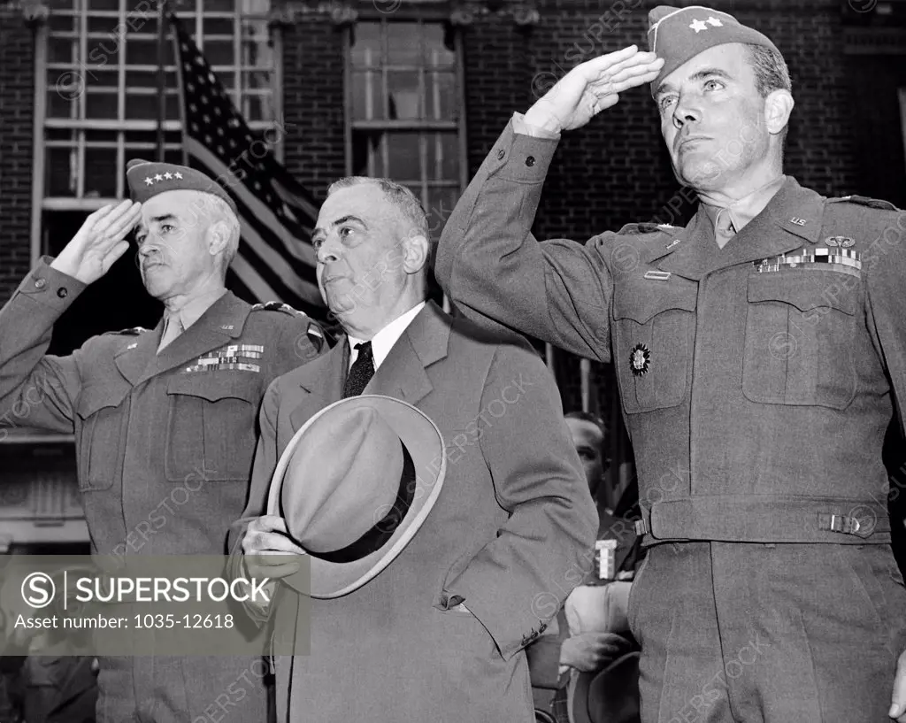 Philadelphia, Pennsylvania:  June 6, 1945 L-R: General Omar Bradley, Philadelphia Mayor Samuel, and Maj. General McAuliffe salute as the national anthem is played during their visit to Independence Hall.