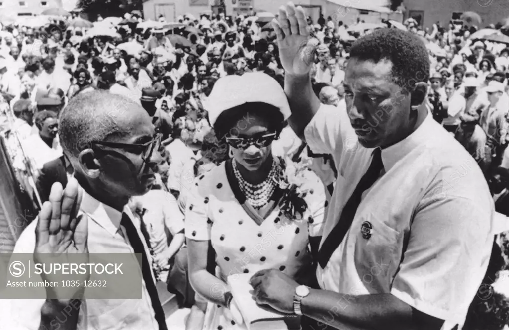 Fayette, Mississippi:   July 7, 1969 Civil rights leader Charles Evers is sworn in as mayor of Fayette, Mississippi by Justice of Peace Willie Thompson. Mrs. Evers holds the Bible for her husband. Charles is the brother of slain rights activist Medgar Evers.