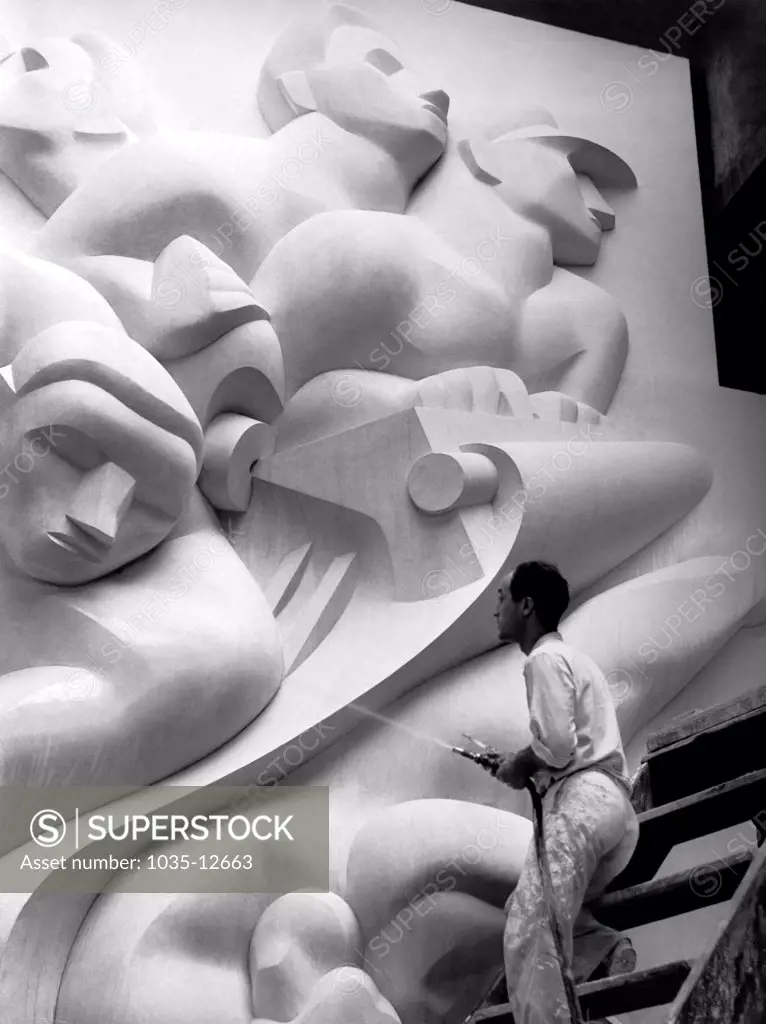 New York, New York:  1940 Isamu Noguchi working on the Associated Press Building Plaque, which was carved in plaster and cast in stainless steel - at that time the largest-ever stainless steel casting.  It is still installed in Rockefeller Center.