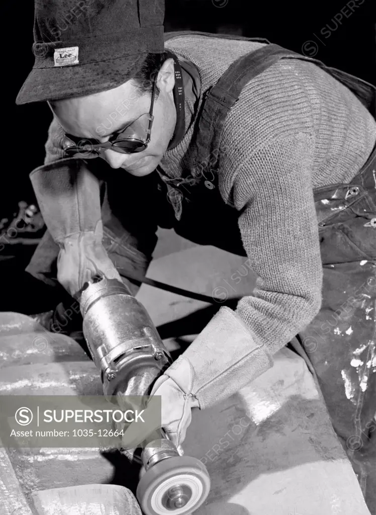 New York, New York:  1940 Isamu Noguchi working on the Associated Press Building Plaque, which was carved in plaster and cast in stainless steel - at that time the largest-ever stainless steel casting.  It is still installed in Rockefeller Center.