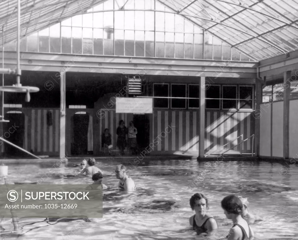 Warm Springs, Georgia:  1928. Franklin Roosevelt exercises his polio damaged legs in the enclosed pool at Warm Springs, Georgia.