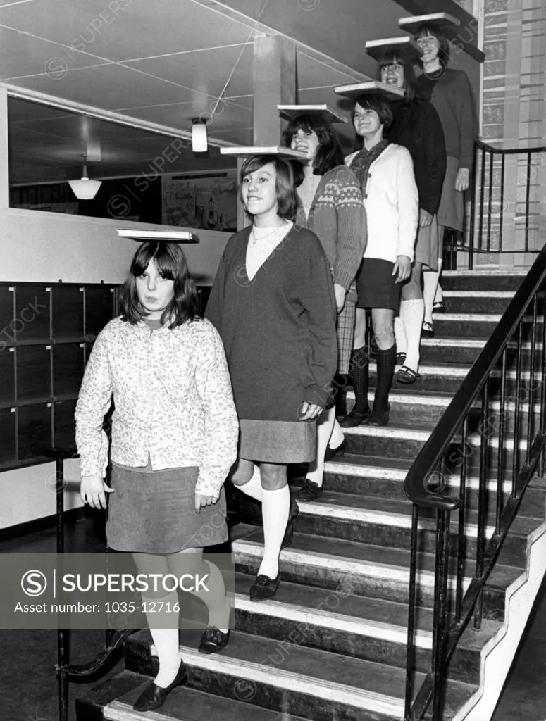Whitworth, England:  January 21, 1967 With books balanced on their heads, secondary school girls at Whitworth learn the art of deportment in the 'Modern Studies' program.