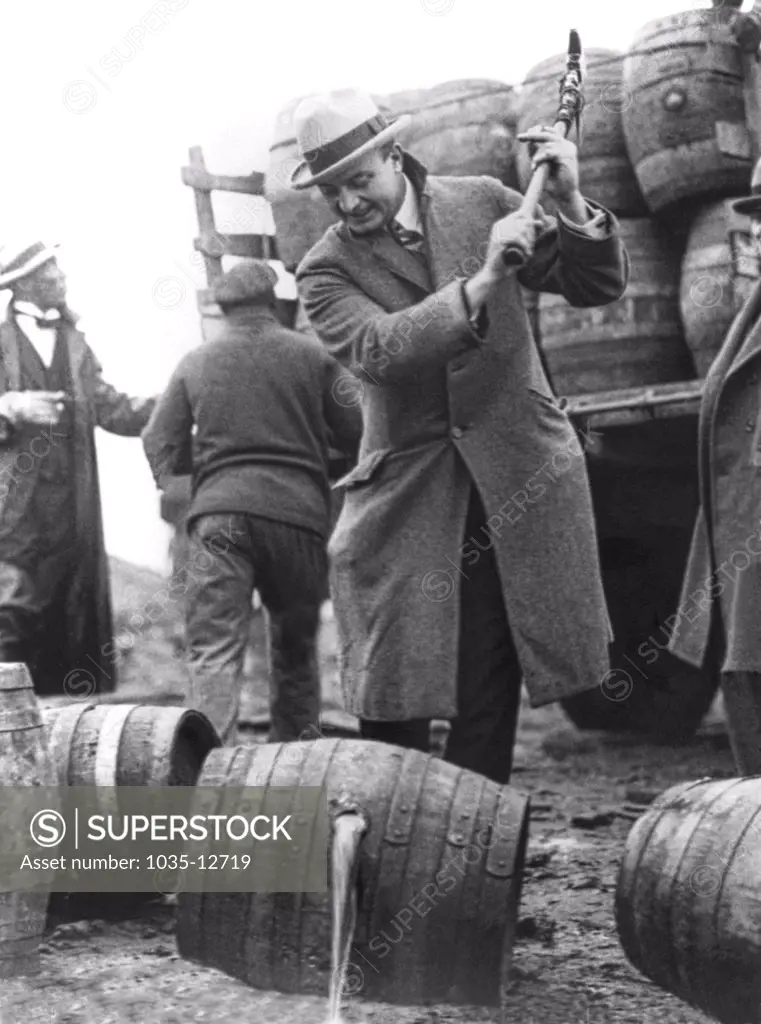 Philadelphia, Pennsylvania:  December, 1924 Public Safety Director Smedley D. 'Duckboards' Butler destroying barrels of beer with a pick axe during Prohibition and letting it run into the  Schuylkill River.