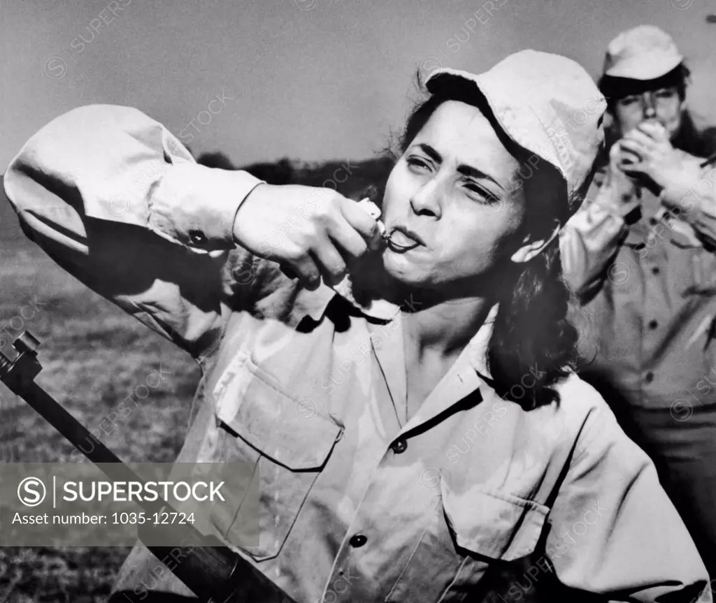 Cairo, Egypt:  June 2, 1967 A female member of the Futewa, or Naitonal Guard battalions made up of UAR student volunteers, pulls the pin from a hand gernade with her teeth during training in a camp. A total of 113 Futewa battalions will be formed in Cairo and 30 more in Alexandria.